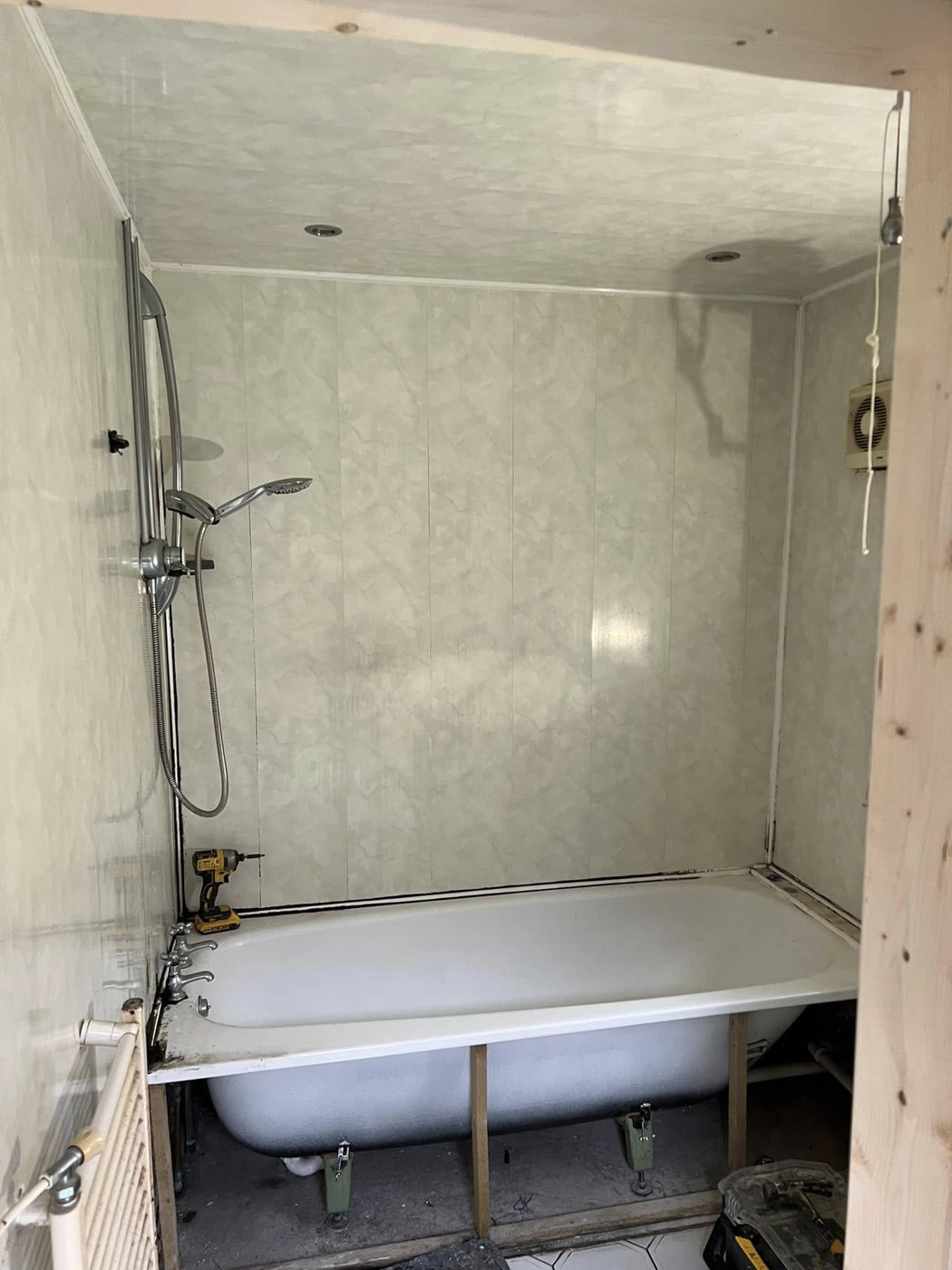 Bathroom before renovation — original bath mid strip-out